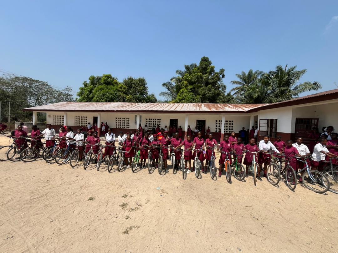 Two students with their new bicycles in front of Wesleyan Secondary School Kamakuwie
